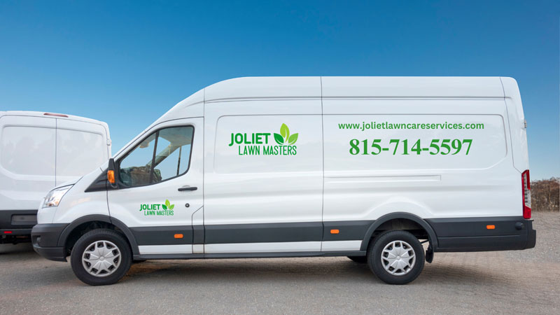 A white van with "Joliet Lawn Care" written on the side, indicating a landscaping service.